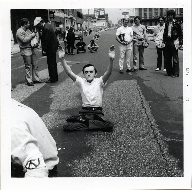 a student protests the Vietnam War in the street on campus