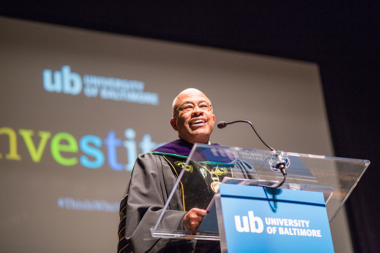 Kurt Schmoke speaks at a podium during his investiture, a traditional welcoming ceremony for a new president.