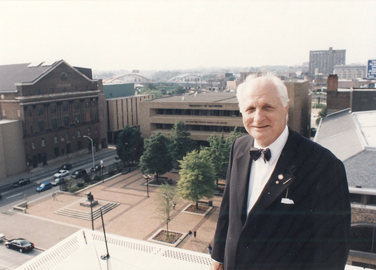 Longtime UBalt President Turner stands atop the Business Center with a view of the building named in his honor just beyond him.