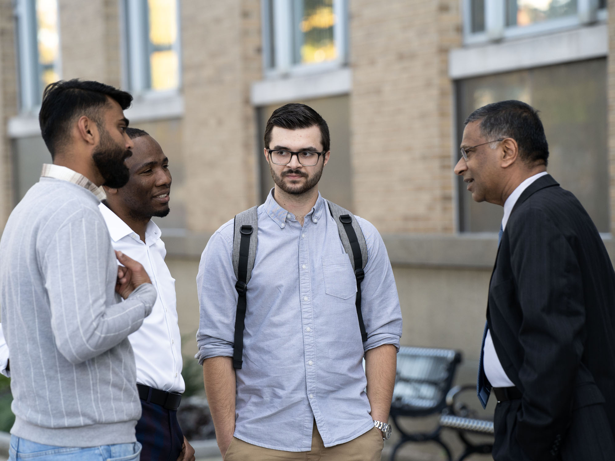 Dean Raju Balakrishnan and three male Merrick School of Business students